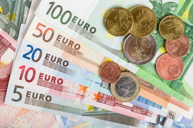 quelques pièces en euros posées sur des billets de banque euros