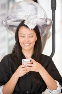 Une femme chez le coiffeur sous l'appareil pour la couleur.