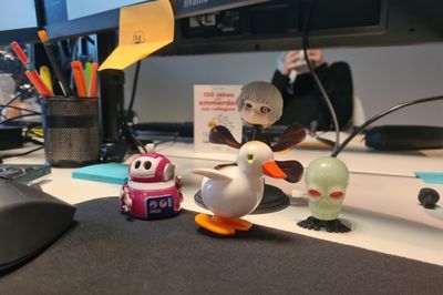 Gros plan sur des figurines de canard, robot et crane mécanique en plastique posé sur un bureau