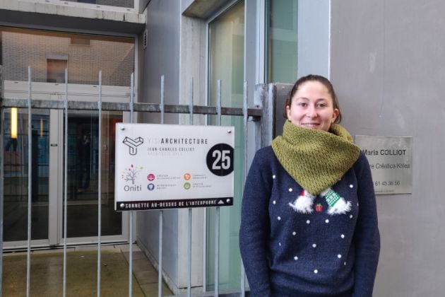 portait d'elisabeth devant le panneau d'entrée de l'agence Oniti