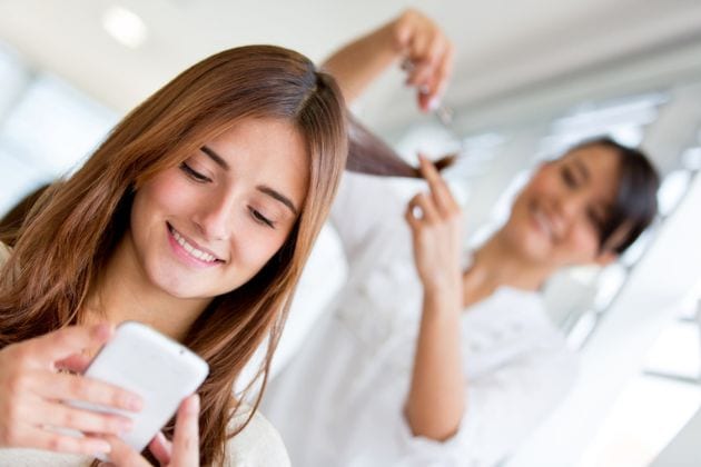 Une femme chez le coiffeur qui lui coupe les cheveux