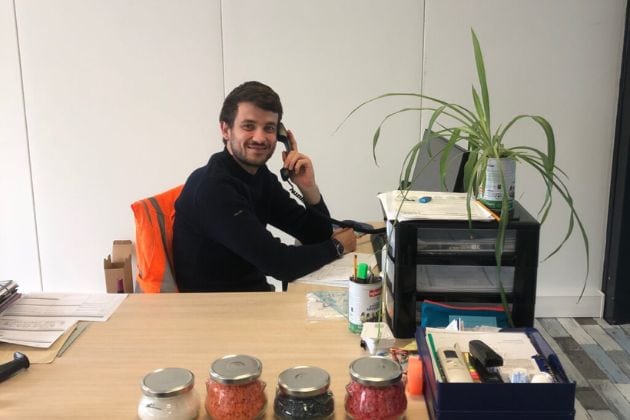 portait d'un homme au téléphone derrière son bureau