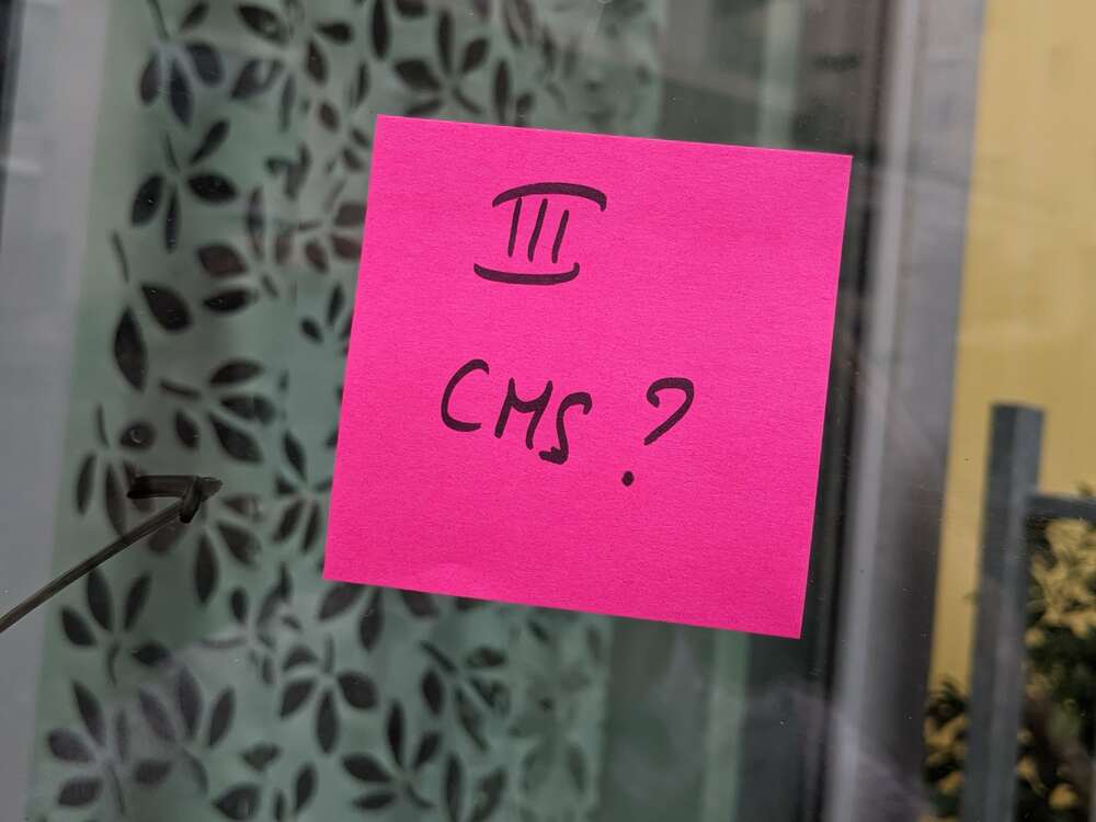 Post-it collé sur une vitre sur lequel est inscrit "3 CMS ?"