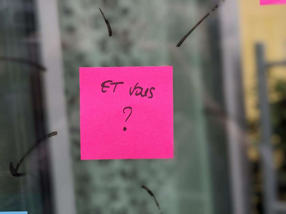 Post-it collé sur une vitre sur lequel est inscrit "Et vous ?"