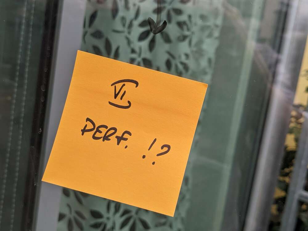 Post-it collé sur une vitre sur lequel est inscrit "6 Perf ?"