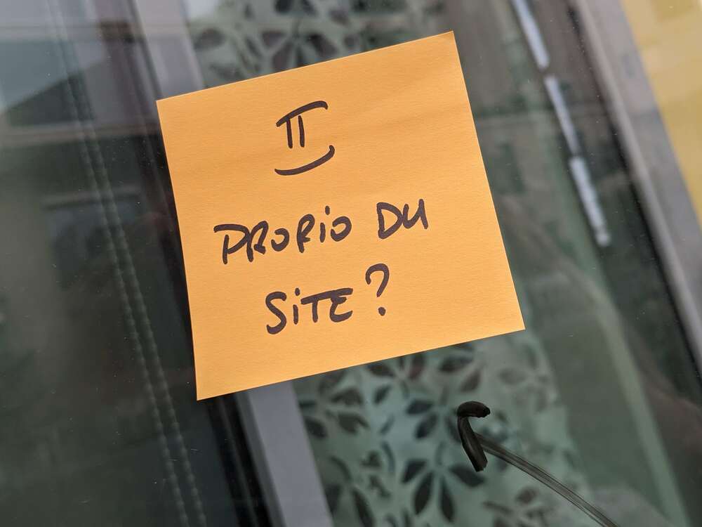 Post-it collé sur une vitre sur lequel est inscrit "2 Proprio du site ?"
